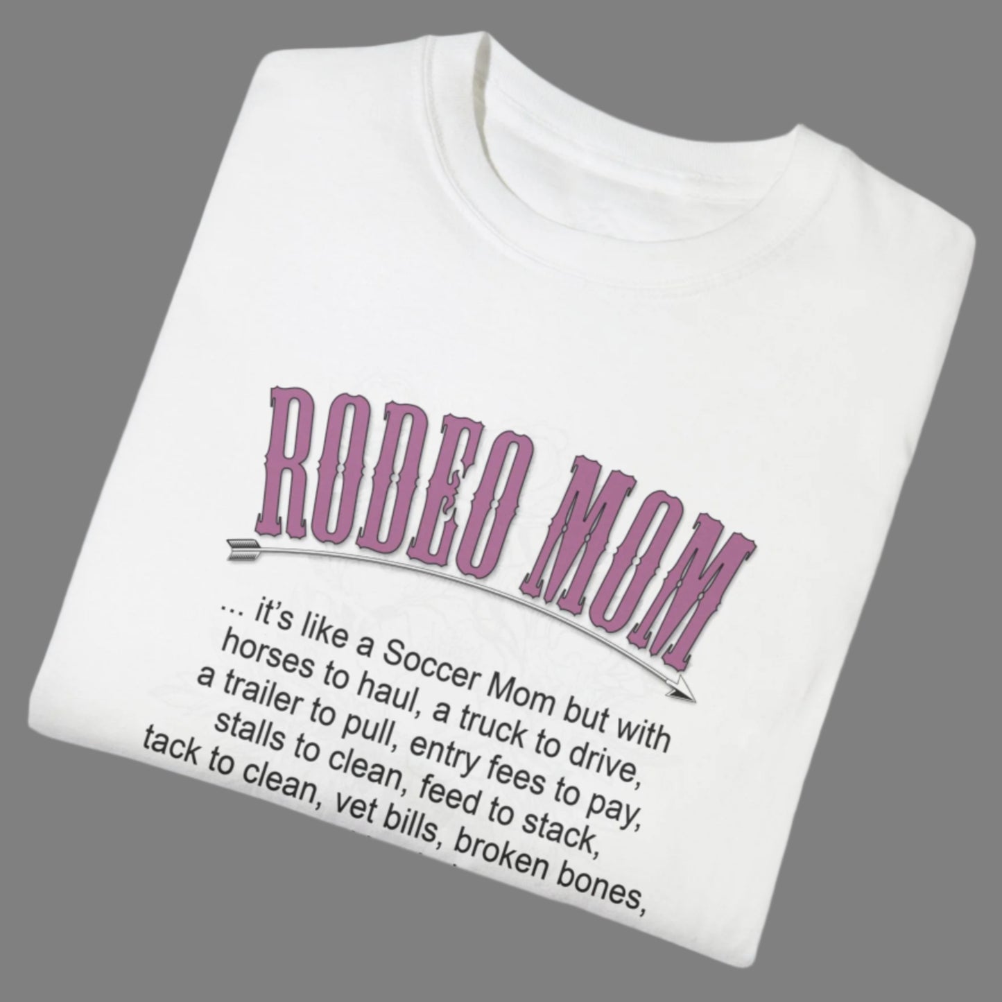 Garment dyed t-shirt imprinted with our exclusive Rodeo Mom design on the front. RODEO MOM it's like a Soccer Mom but with horses to haul, a truck to drive, a trailer to pull, entry fees to pay, stalls to clean, feed to stack, tack t clean, vet bills, broken bones, and hat hair.