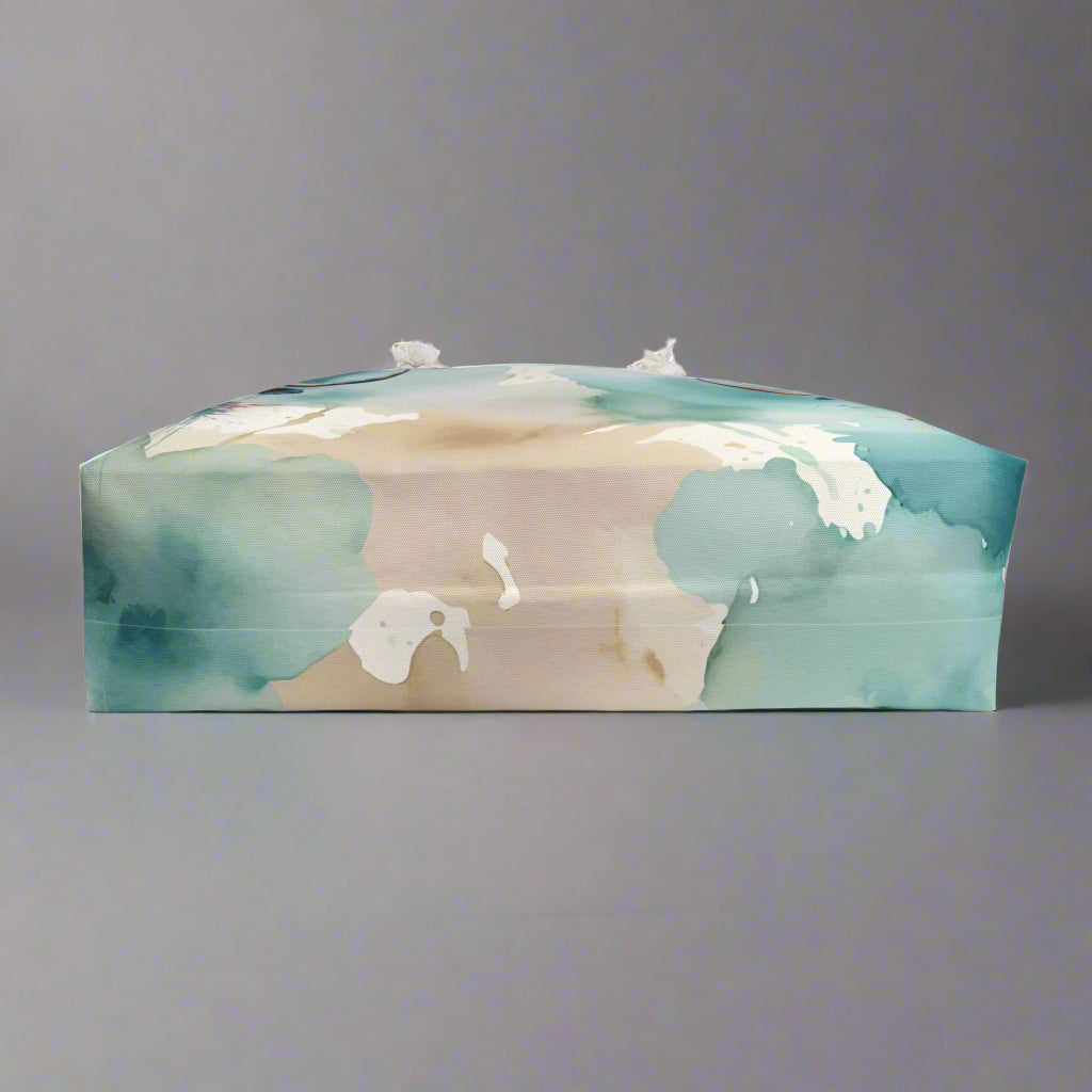 Colorful imprint of watercolor background with steer heads on the ends of the bag. Large overnight style tote bag with white rope handles.