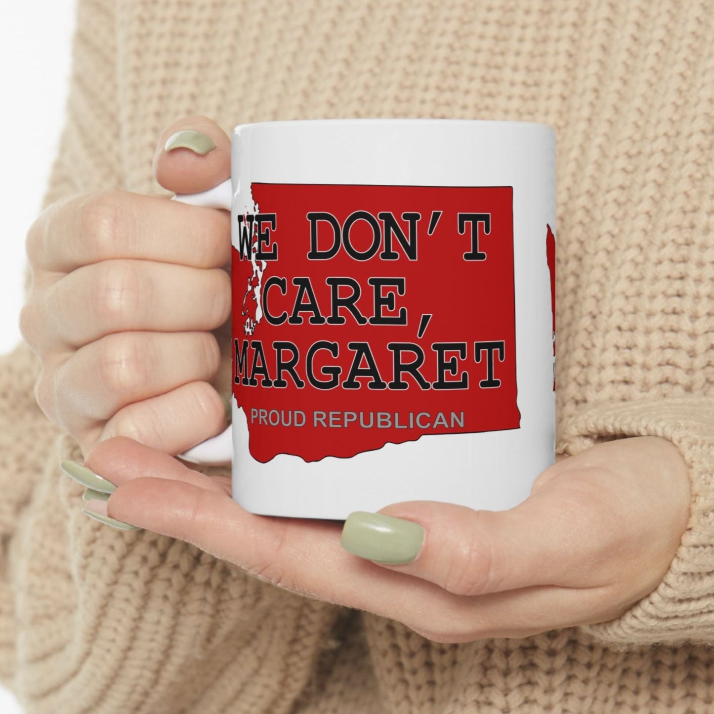 White 11 oz. ceramic coffee mug imprinted on both sides with a red shape of Washington state. Over the top of the image is WE DON'T CARE, MARGARET and Proud Republican. Mug made from an imported base and printed in USA.