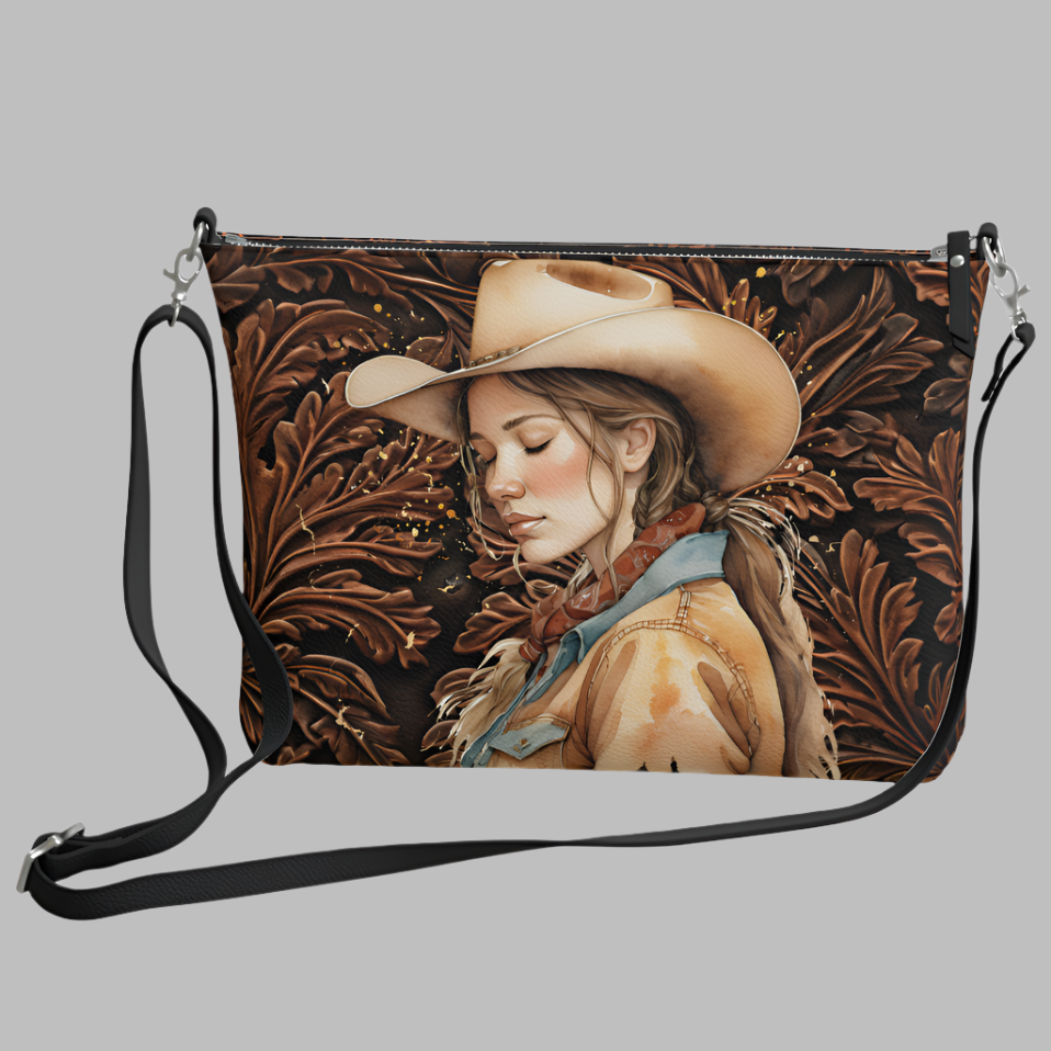 Tooled leather-look all over print faux leather crossbody bag with adjustable strap. We've added our peaceful cowgirl to one side to add some real cowgirl flare. On the other side, one of our favorite Bible verses. 