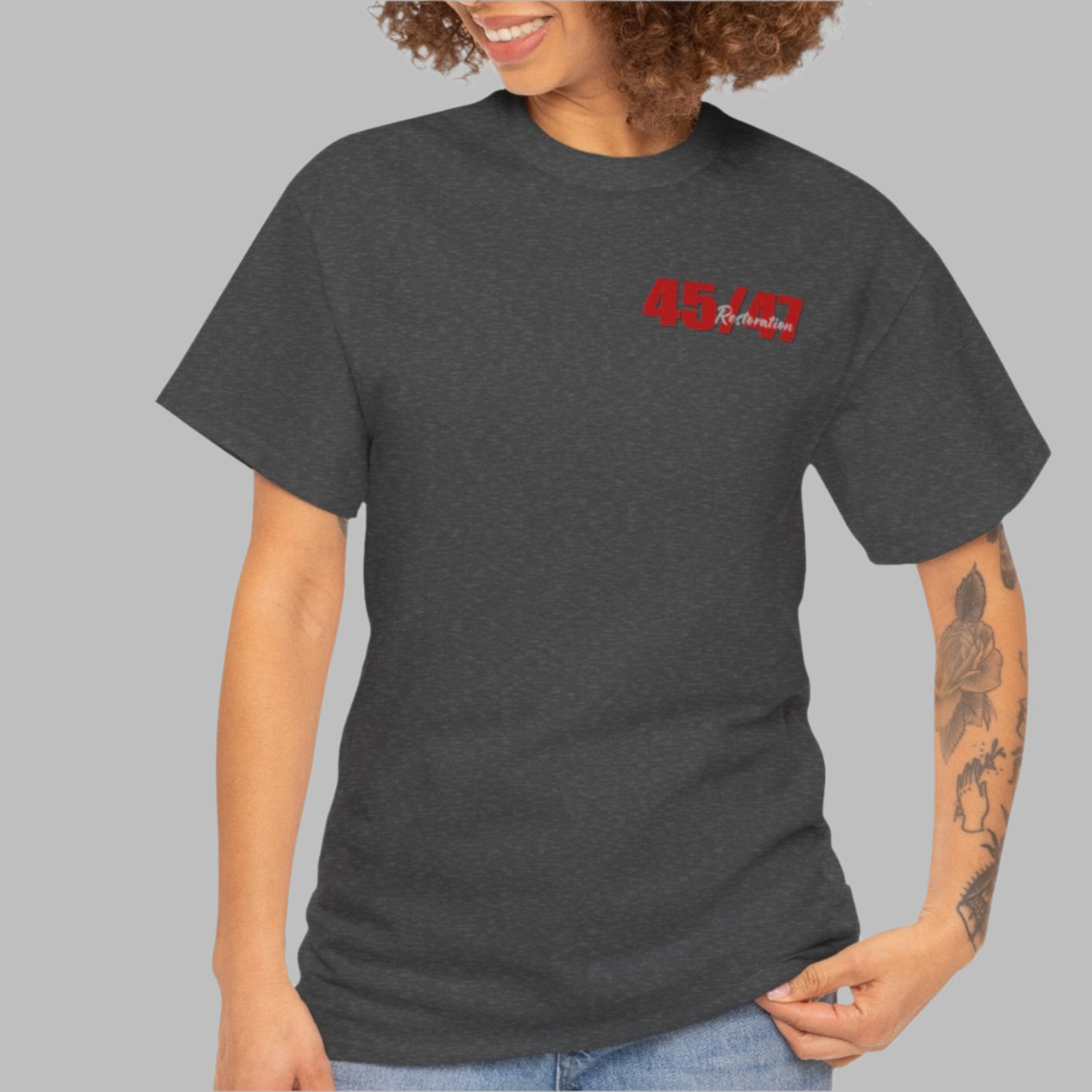 Cotton t-shirt imprinted in red with a gray overprint on the back of the names and strongest qualities of President Trump and his cabinet members / nominees. The front is imprinted on the left chest with 45/47 and the word Restoration overprinted in gray. 