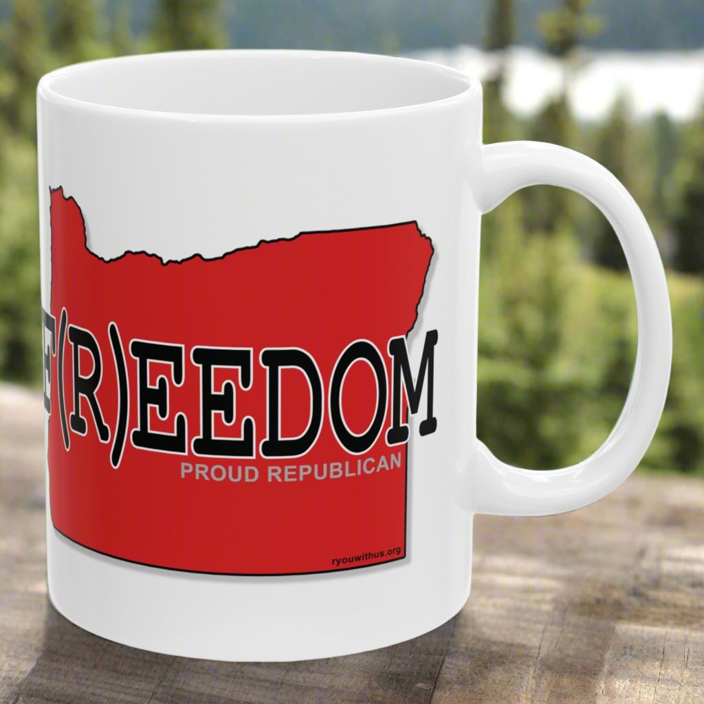 White ceramic 11 oz. mug with red shape of the state of Oregon outlined in black. Across the image of the state is the word F(R)EEDOM and Proud Republican.