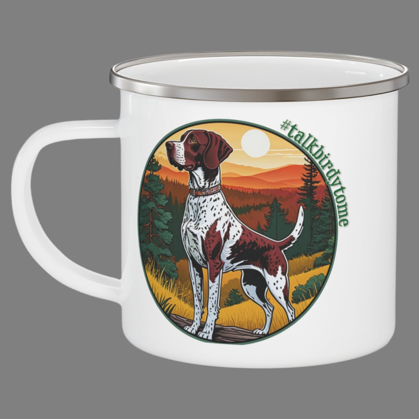 Enamel mug with imprint of German shorthaired pointer ready to go to work.  Shows dog at the ready and waiting to retrieve a bird. Pretty sunrise over distant mountains with golden grasses and green pine trees. Encircled with the tag line #talkbirdytome. White enamel coated stainless steel camping coffee mug. Same imprint on both sides.