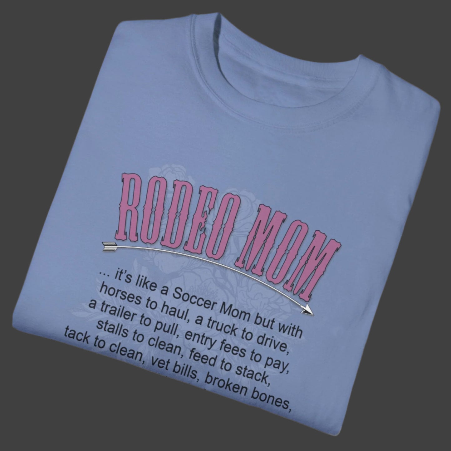 Garment dyed t-shirt imprinted with our exclusive Rodeo Mom design on the front. RODEO MOM it's like a Soccer Mom but with horses to haul, a truck to drive, a trailer to pull, entry fees to pay, stalls to clean, feed to stack, tack t clean, vet bills, broken bones, and hat hair. 