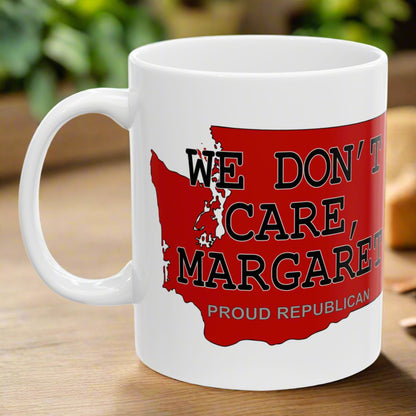 White 11 oz. ceramic coffee mug imprinted on both sides with a red shape of Washington state. Over the top of the image is WE DON'T CARE, MARGARET and Proud Republican. Mug made from an imported base and printed in USA.