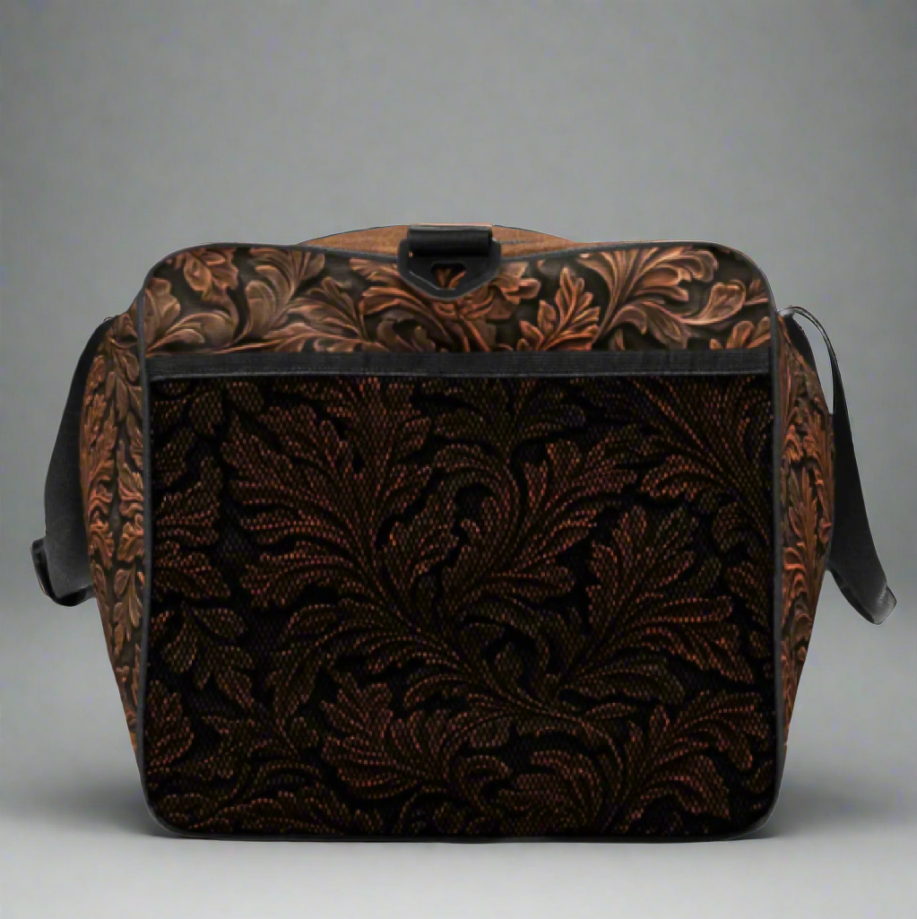 Oversize duffle bag imprinted with classic western tooled-leather look on sides and ends. Pebble leather print on tops and bottom. Peaceful cowgirl and Bible verse imprinted on top flap. Black carrying straps and handles. Bag has exterior mesh pocket on one end and multiple interior pockets. 