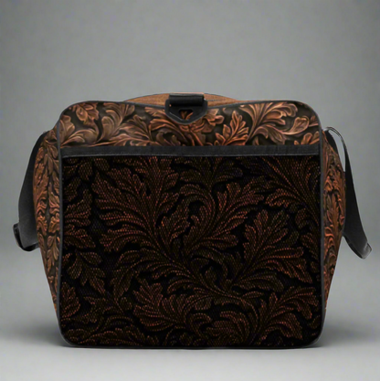 Oversize duffle bag imprinted with classic western tooled-leather look on sides and ends. Pebble leather print on tops and bottom. Peaceful cowgirl and Bible verse imprinted on top flap. Black carrying straps and handles. Bag has exterior mesh pocket on one end and multiple interior pockets. 