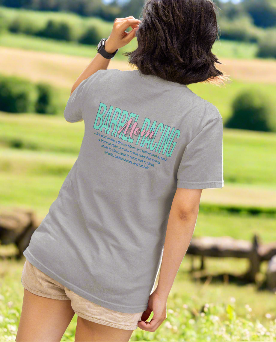 Woman in short sleeve crew neck t-shirt imprinted with Barrel Racing Mom on the back. 