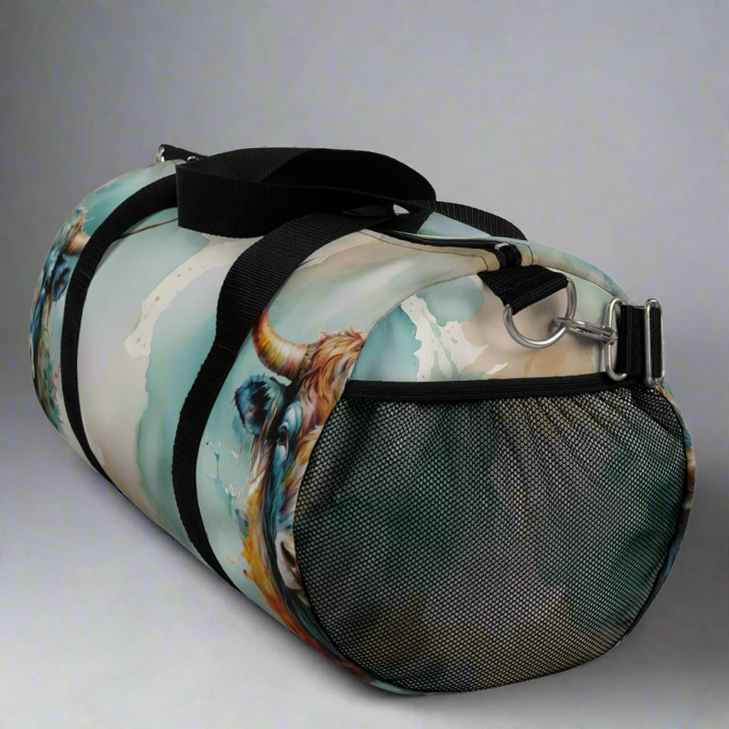 Our large size duffle bag features a pretty teal blue and green watercolor wash with shades of tan, light brown, and cream. We've added our fancy colorful steer to both sides. Bag has a removable shoulder strap, handles, and a mesh exteriror pocket. 